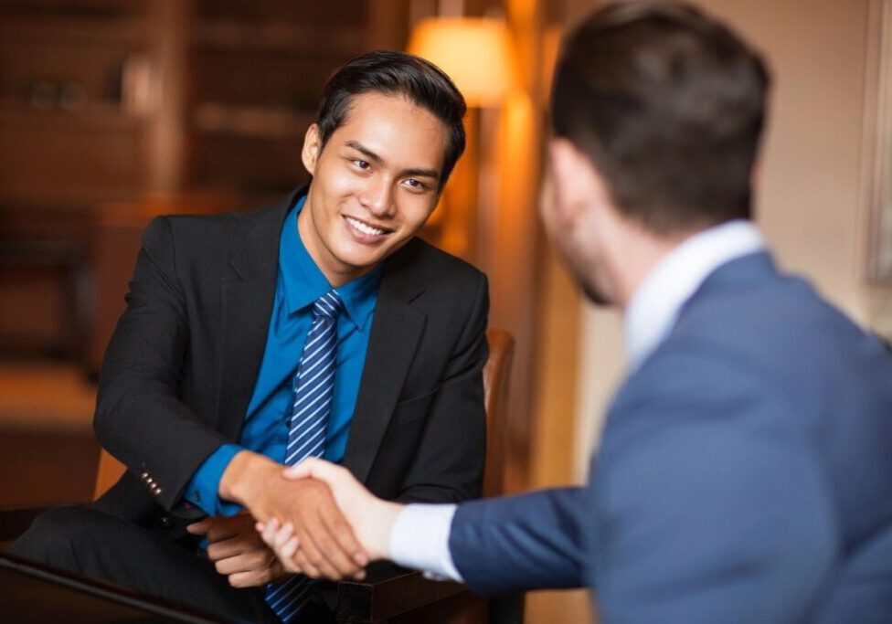 Two men shaking hands in a restaurant.